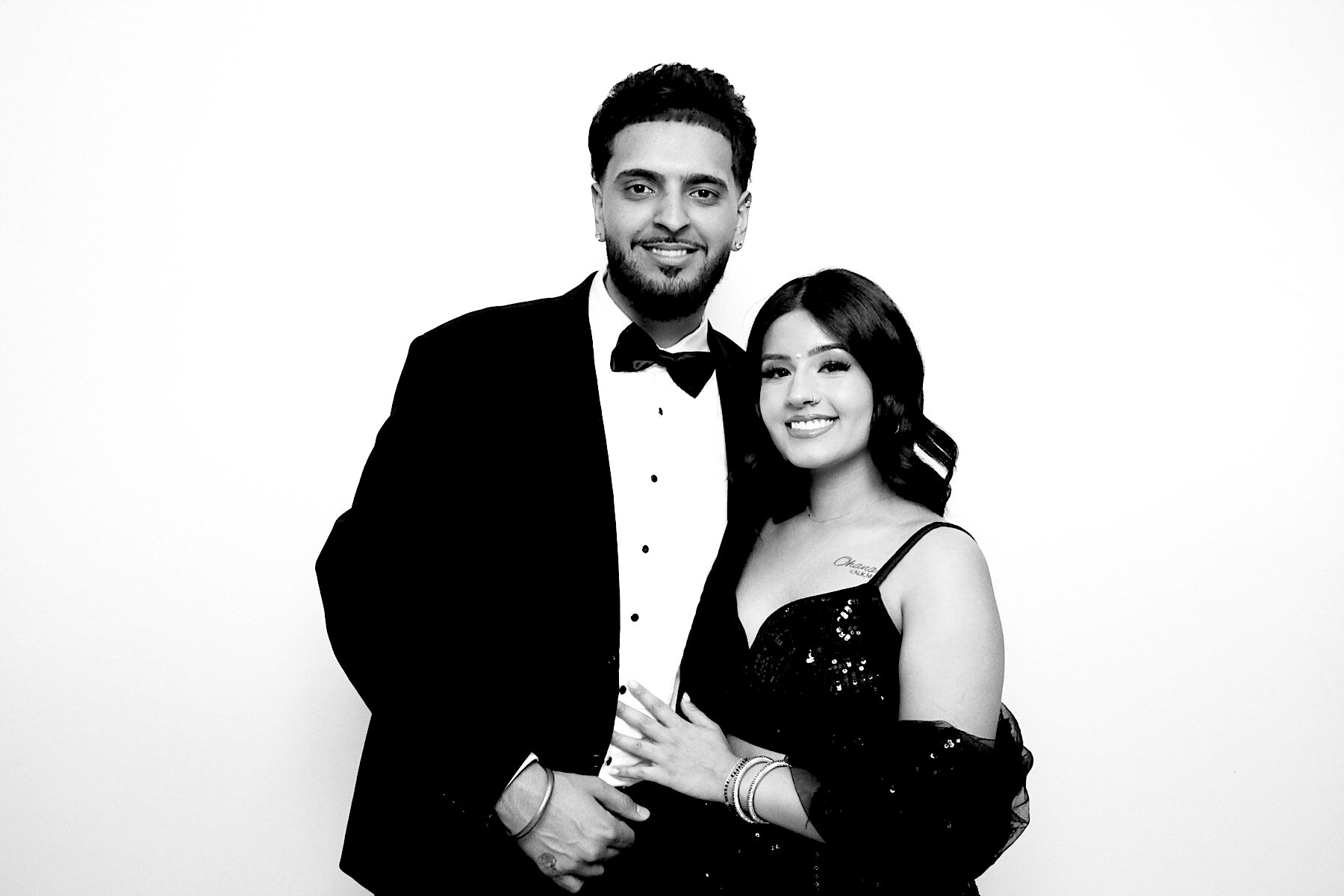 Guests smiling together in a black-and-white photo booth portrait