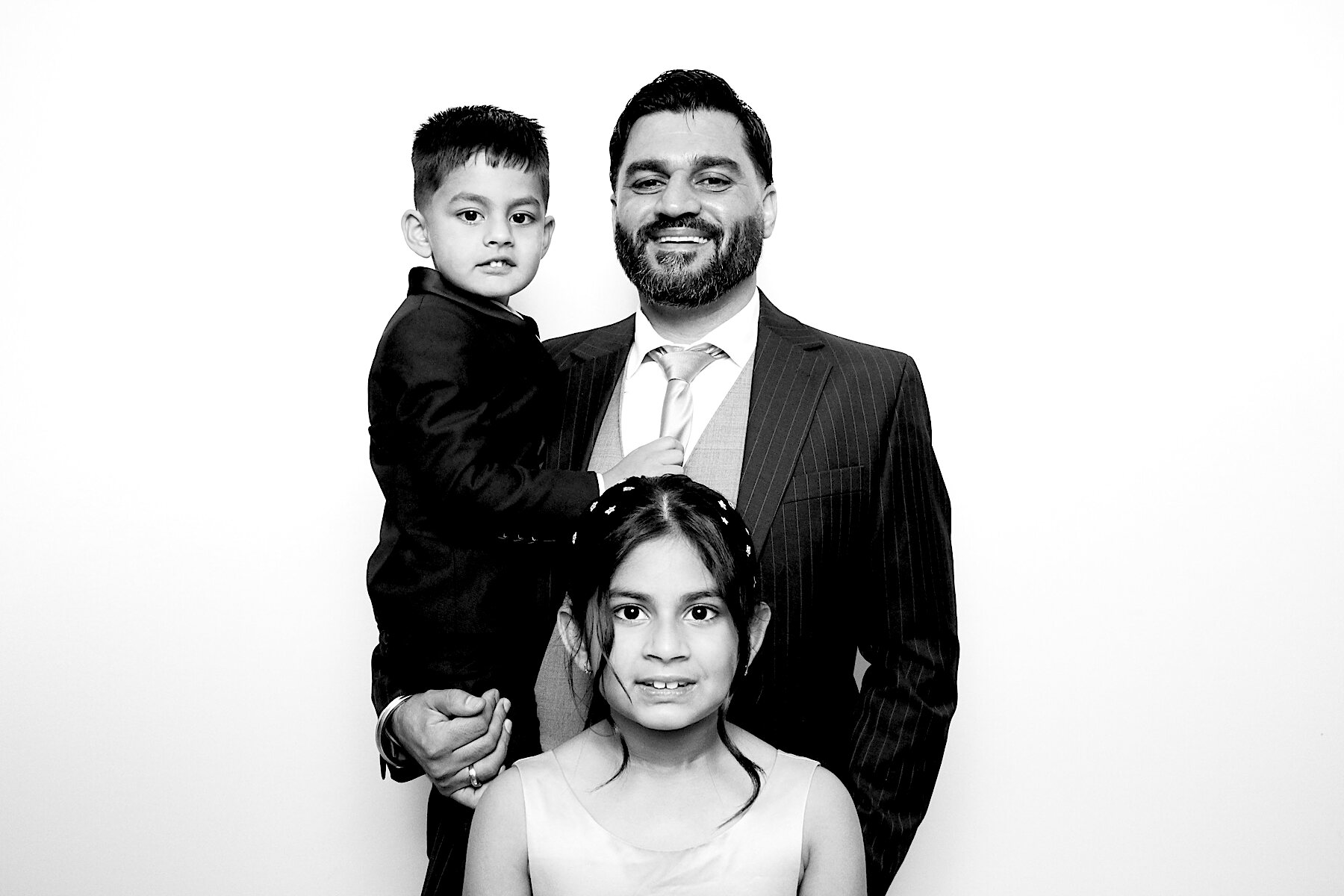 Father with his two children dressed up for a celebration, in black and white